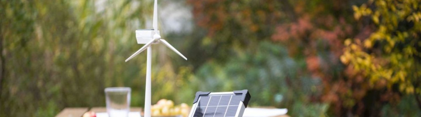 Windenergie Modell und Solar Modul auf Tisch im Garten